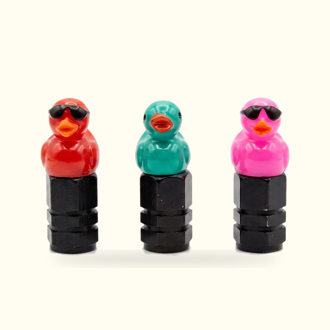 Red, teal and hot pink duck valve caps in a row
