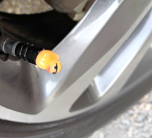 Orange duck valve cap installed on an alloy wheel